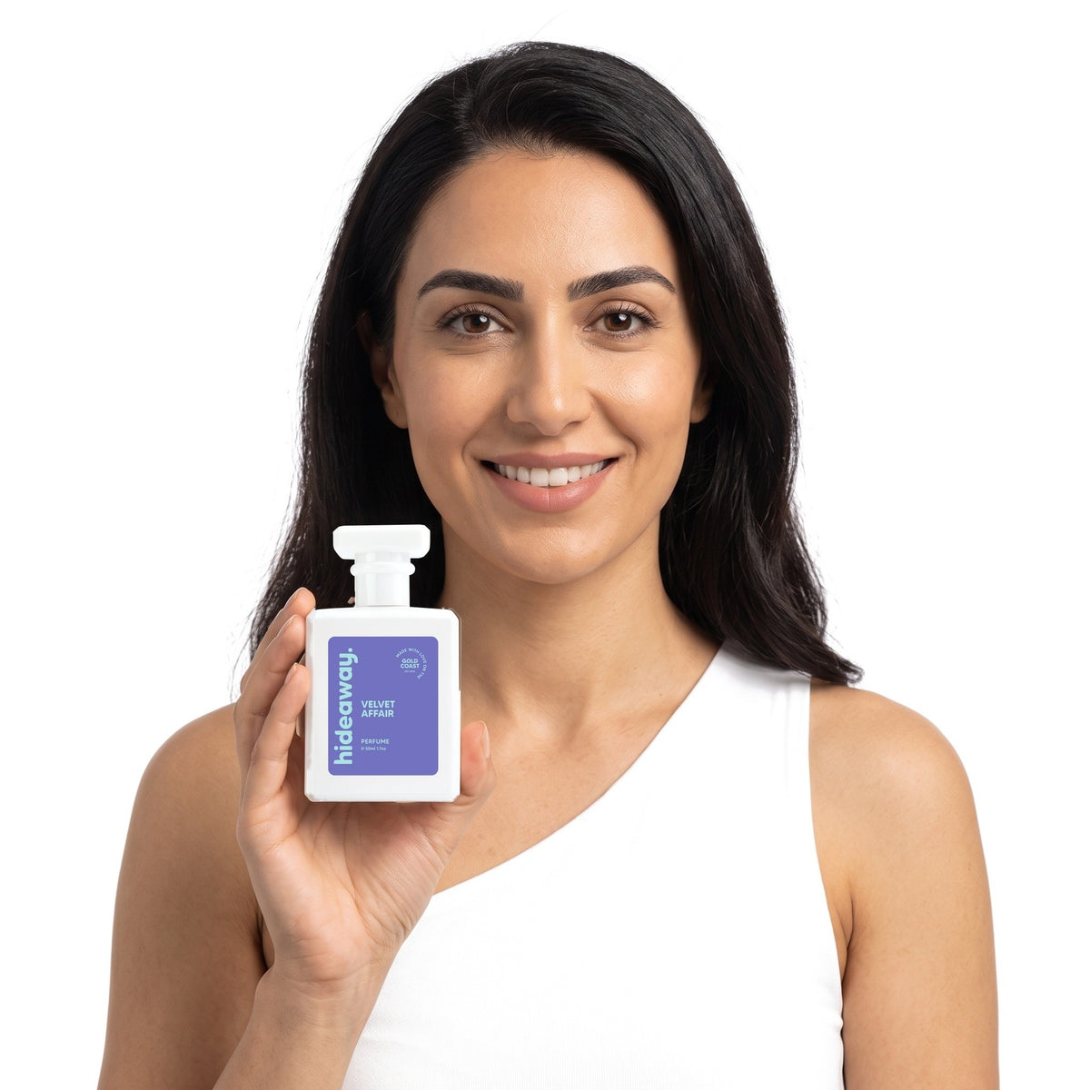 A smiling woman holding Hideaway. Velvet Affair perfume